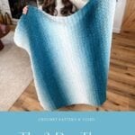 A woman holds up a cozy blue and white gradient 2-day throw crochet blanket in a living room, with a fireplace and festive holiday decorations in the background. Text reads "The 2-Day Throw.