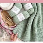 A green crocheted blanket, three skeins of matching yarn, crochet hooks, and a pink striped cloth are arranged on a surface with text promoting a reversible crochet pattern for a sailboat baby blanket.