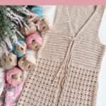 A beige crochet vest is displayed beside several skeins of colorful cotton yarn, a crochet hook, and flowers. Text reads: "Summer Crochet Vest," "Solstice Vest Pattern," and includes inspiration for your next projectโperfect for those who love a free crochet poncho pattern with summer flair.